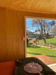 two wine glasses on a table in a room with a window at Ruapehu Views Cabin Getaway in Raetihi