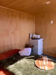 a small room with a refrigerator and a table at Ruapehu Views Cabin Getaway in Raetihi
