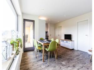 a dining room with a table and green chairs at Bungalow im Campingpark in Waxweiler
