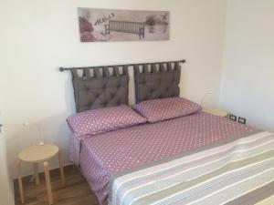 ローマにあるLa casa per teのベッドルーム1室(紫のシーツが敷かれたベッド1台、ベンチ付)