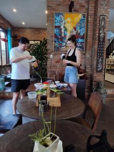 a man and a woman standing around a table at Calm House Hotel Hoi An 1 in Hoi An +91 photos