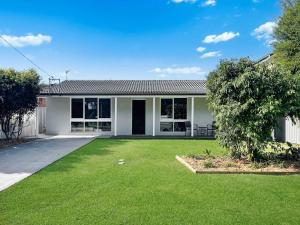 a house with a green lawn in front of it at Oak Flats Escape in Oak Flats