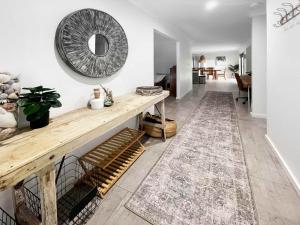a living room with a wooden table and a mirror at Oak Flats Escape in Oak Flats