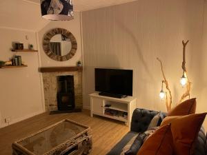 a living room with a couch and a flat screen tv at Braeburn in Bamburgh