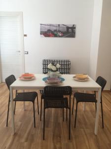 ローマにあるLa casa per teの白いテーブルと椅子(皿、ボウル付)