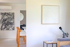 a living room with a blue couch and a table at Glenmohr Cottage in Waipu