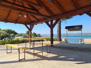 a picnic table and benches in front of the beach at Beach Sea View House Nevidane Pasman in Neviđane