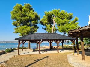 a pavilion at the beach with trees in the background at Beach Sea View House Nevidane Pasman in Neviđane