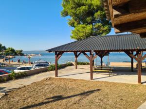 a pavilion on the beach with a view of the water at Beach Sea View House Nevidane Pasman in Neviđane