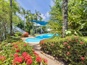 a resort with a swimming pool and flowers at Island Orchid in Airlie Beach