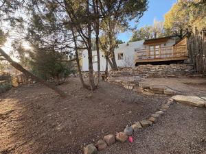 a yard with a house with a fence and trees at High Moon 4 Ten Thousand Waves Way in Santa Fe