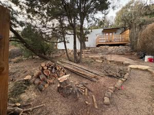 a pile of logs on the ground in front of a house at High Moon 4 Ten Thousand Waves Way in Santa Fe +5 photos
