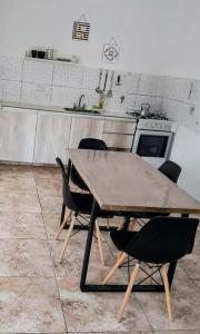 a wooden table and chairs in a kitchen at Depto Civora 5 in Villa Regina +3 photos
