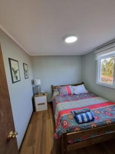 a small bedroom with a bed and a window at Cabaña 2 a 4 personas in Carahuo