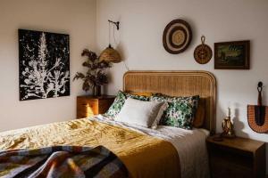 a bedroom with a large bed and some pictures on the wall at Moonbird Beach Shack ~ Ocean Escape in Beaumaris Tasmania