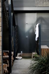 a wooden walkway leading to a door of a house at Moonbird Beach Shack ~ Ocean Escape in Beaumaris Tasmania +25 photos
