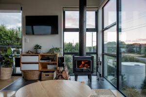 a living room with a fireplace and a table at Moonbird Beach Shack ~ Ocean Escape in Beaumaris Tasmania