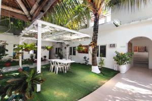 ein Zimmer mit Tisch und Stühlen und einer Palme in der Unterkunft Boracay Backpackers in Boracay