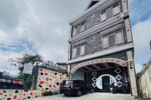 a car parked in front of a building at RedDoorz at Ingan Cio Homestay Berastagi in Berastagi