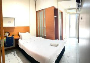 a hotel room with a large bed and a desk at Sang Surya Guest House in Bandung