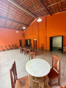 a room with a table and chairs and orange walls at Sítio Castelo Branco - Morretes in Morretes