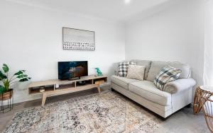 a living room with a couch and a flat screen tv at Oak Flats Escape in Oak Flats