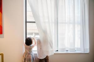 a little girl is looking out of a window at KIORI Collection Shinmachi in Kyoto