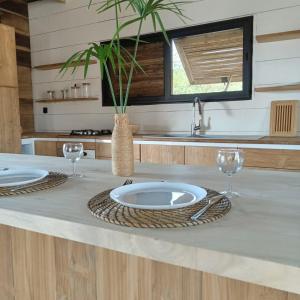 a kitchen with a table with two plates and glasses at Villa Aïdo in Ouidah