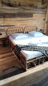 a large metal bed sitting on top of a wooden floor at Villa Aïdo in Ouidah