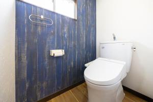 a white toilet in a bathroom with a blue wall at -Shibamata House- 9-minute walk from Shibamata Station in Tokyo