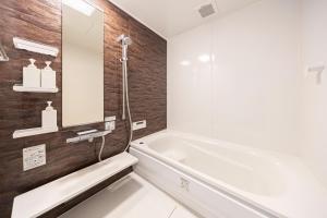 a white bathroom with a tub and a sink at -Shibamata House- 9-minute walk from Shibamata Station in Tokyo