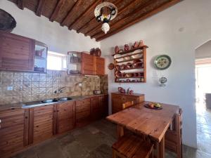 a kitchen with wooden cabinets and a wooden table at Kimoliatiko in Kimolos