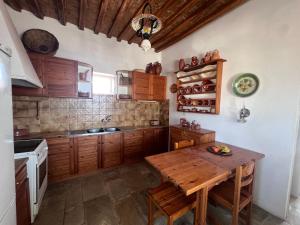 a kitchen with wooden cabinets and a wooden table at Kimoliatiko in Kimolos +56 photos