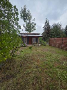 a small house in a yard with a fence at Alojamiento Pamela in Coñaripe