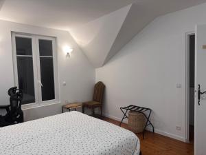 a white bedroom with a bed and a window at Nineja in Fontenay-sous-Bois