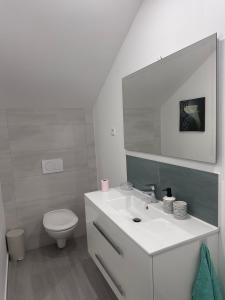 a bathroom with a white sink and a toilet at Nineja in Fontenay-sous-Bois