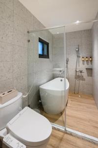 a bathroom with a white toilet and a bath tub at Mr Petter in Taichung