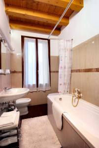 a bathroom with a tub and a toilet and a sink at Villa Dacri in Venice-Lido