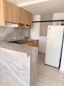 a kitchen with a white refrigerator and a sink at Apartamento Completo en Ricaurte in Ricaurte