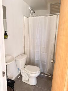 a white bathroom with a toilet and a sink at Apartamento Completo en Ricaurte in Ricaurte +9 photos