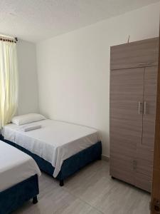 a bedroom with two beds and a dresser at Apartamento Completo en Ricaurte in Ricaurte