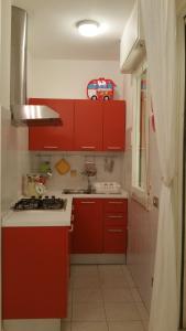 ミザーノ・アドリアーティコにあるCristina' s flatの赤いキッチン(赤いキャビネット、シンク付)