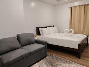 a living room with a couch and a bed at Raya's Staycation Megatower 7 Baguio City in Baguio