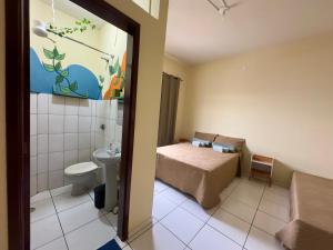 a small room with a bed and a toilet at Loft Central Orgânico in Passos +22 photos