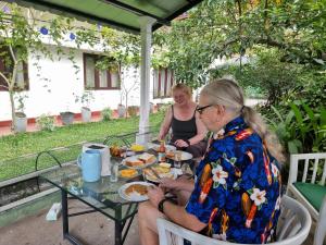 two people sitting at a table eating food at Mahaweli Shades in Kandy