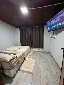 a room with a bed and a flat screen tv at Casa Maipu in Corrientes