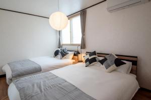 two beds sitting next to each other in a room at Biei Sakura Stay in Biei
