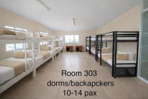 a room with several bunk beds in a room with a hallway at Ciano's Hostel Cebu in Cebu City +3 photos