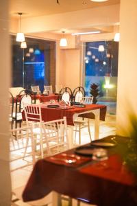 a dining room with tables and white chairs at La Bela Casa Suites, Candolim in Candolim