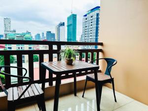 a table and chairs on a balcony with a city skyline at Ramada by Wyndham Phnom Penh Central in Phnom Penh